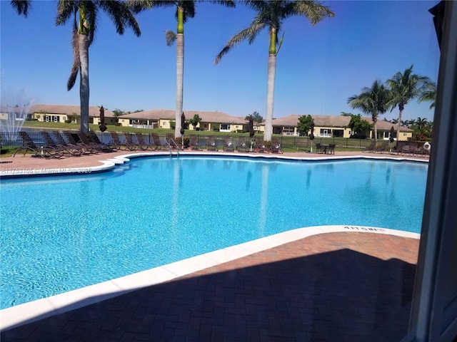 community pool featuring a residential view and fence