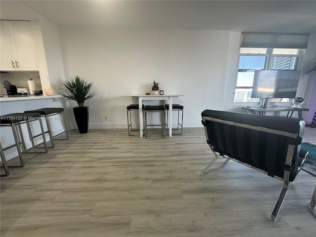 sitting room with baseboards and light wood finished floors