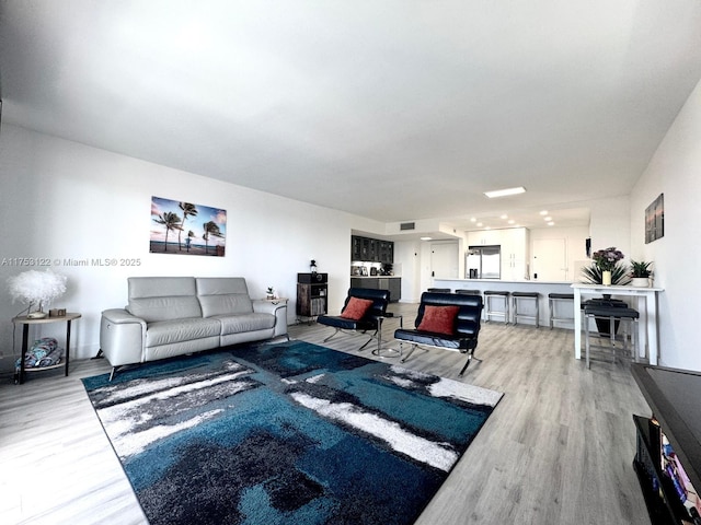 living area with visible vents and light wood-style floors