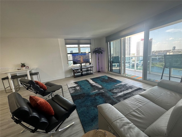 living room featuring a view of city, wood finished floors, and baseboards