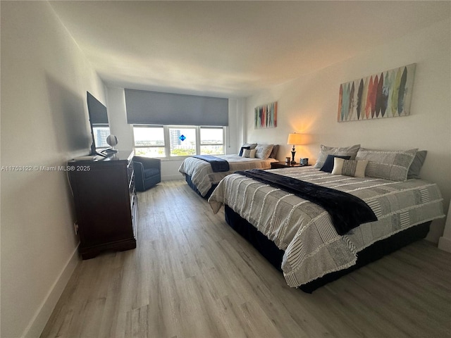 bedroom with light wood-style floors and baseboards