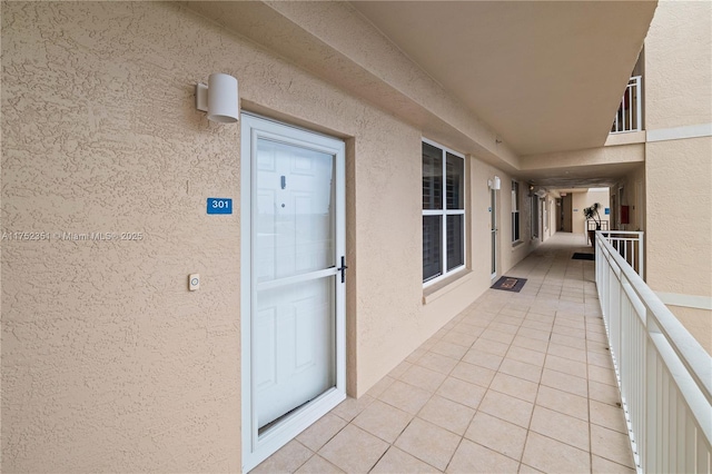 property entrance with a balcony and stucco siding