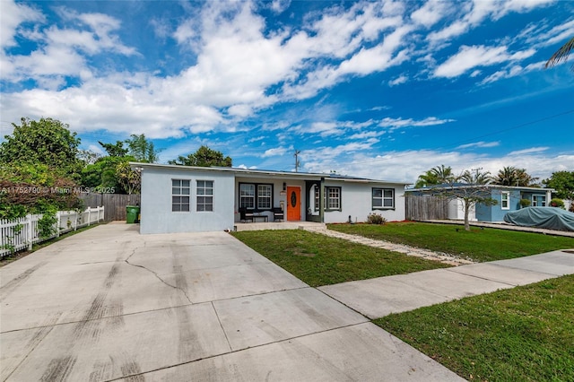 single story home featuring covered porch, fence, a front lawn, and stucco siding