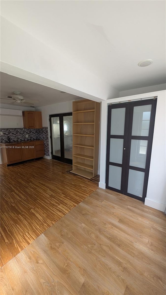unfurnished living room featuring baseboards, french doors, and wood finished floors