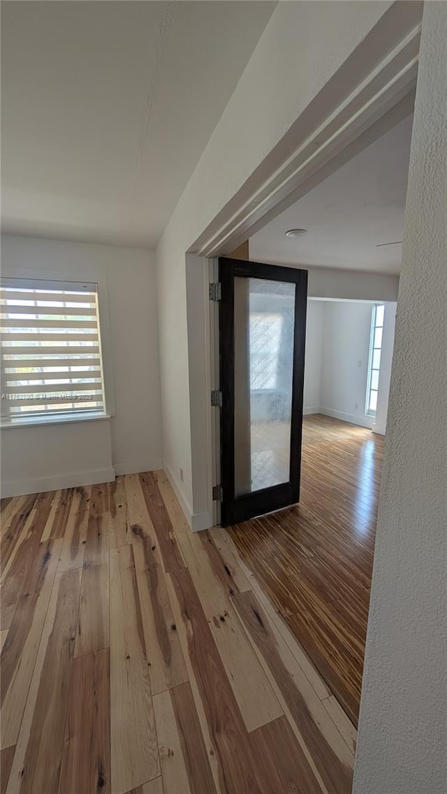spare room with baseboards and hardwood / wood-style floors