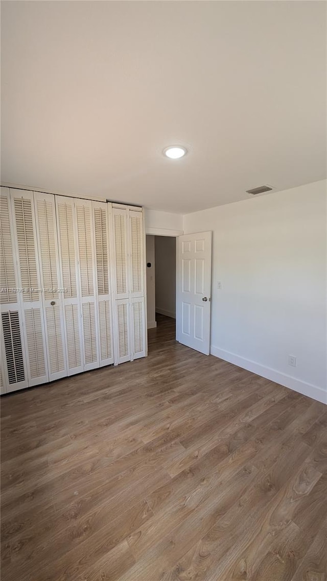 unfurnished bedroom featuring baseboards, recessed lighting, wood finished floors, and visible vents