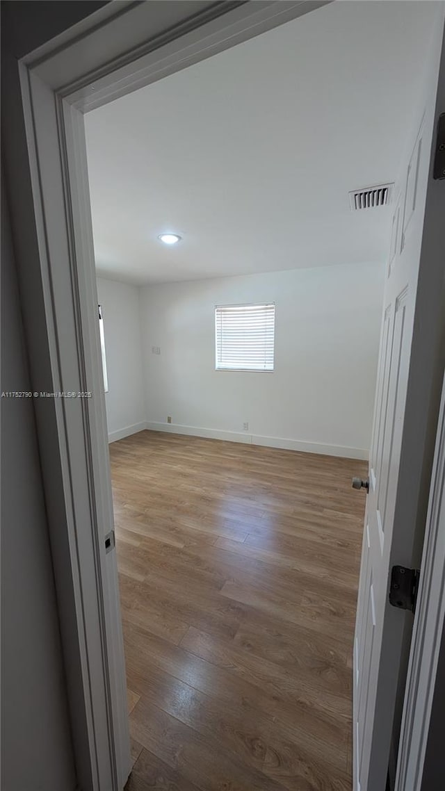 empty room featuring visible vents, recessed lighting, light wood finished floors, and baseboards