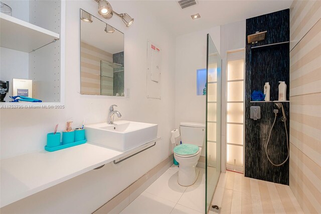 bathroom featuring visible vents, a sink, tile patterned flooring, and toilet