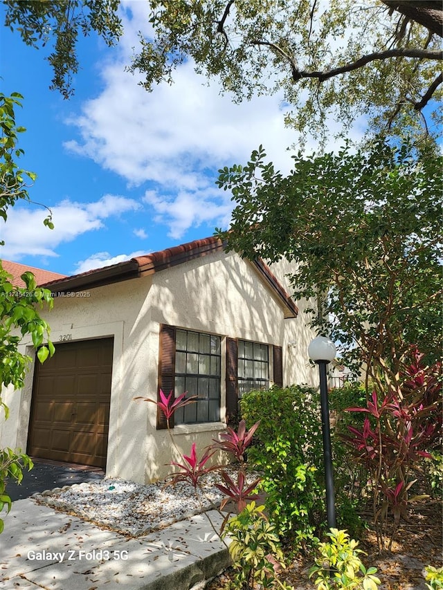 mediterranean / spanish-style home featuring an attached garage and stucco siding