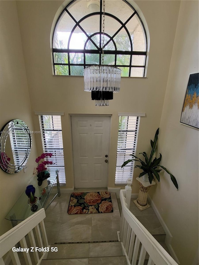 entrance foyer featuring baseboards, plenty of natural light, and a high ceiling