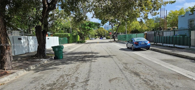 view of road with traffic signs, curbs, and sidewalks