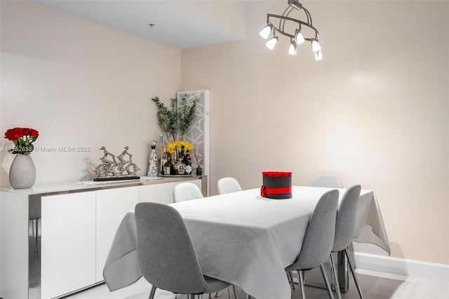 dining room featuring an inviting chandelier and baseboards