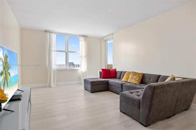 living area featuring light wood-style flooring and baseboards