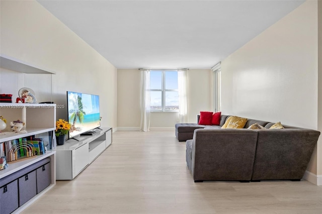 living room with baseboards and light wood finished floors