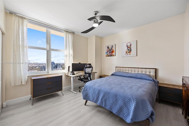 bedroom with ceiling fan, light wood-type flooring, and baseboards