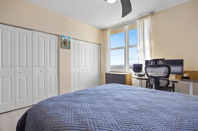 bedroom with multiple closets, wood finished floors, and a ceiling fan