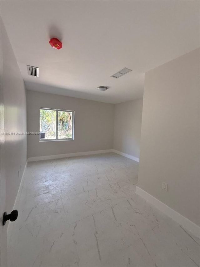 unfurnished room featuring marble finish floor, visible vents, and baseboards