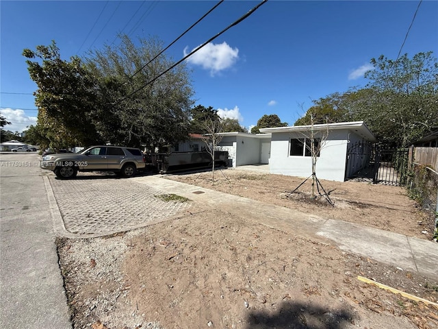 view of front facade with driveway and fence