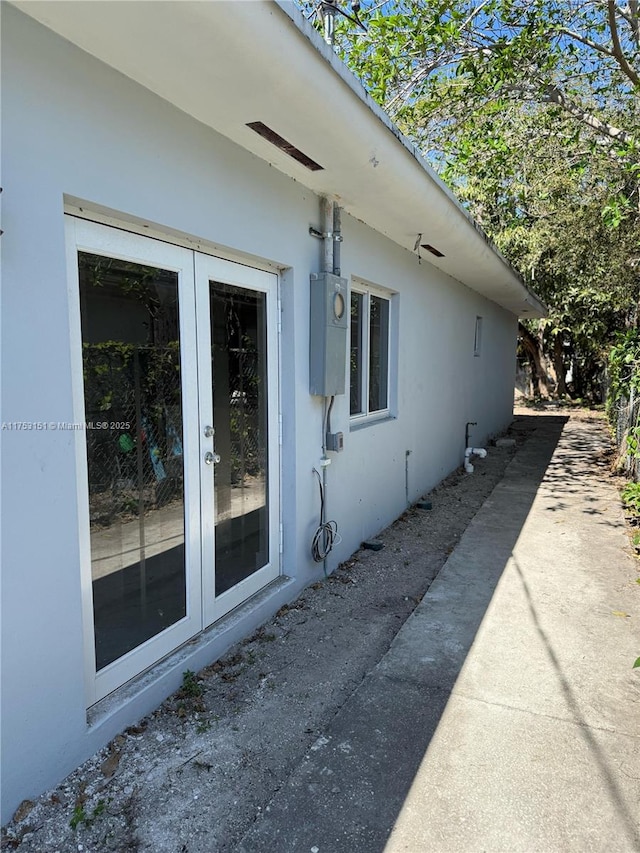 view of side of property with french doors and stucco siding