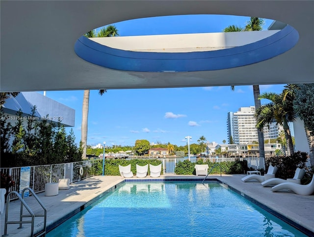 community pool with a patio area and fence