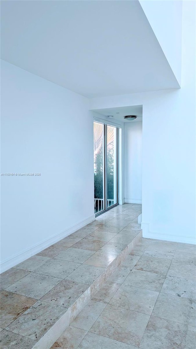 unfurnished room with baseboards