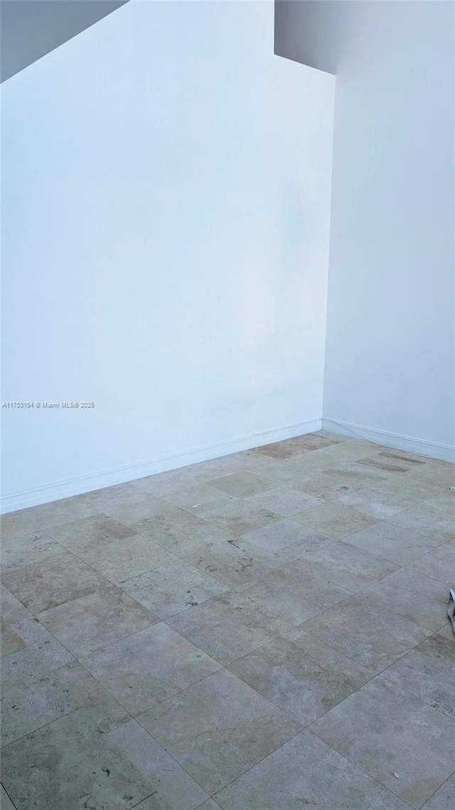 unfurnished room with baseboards