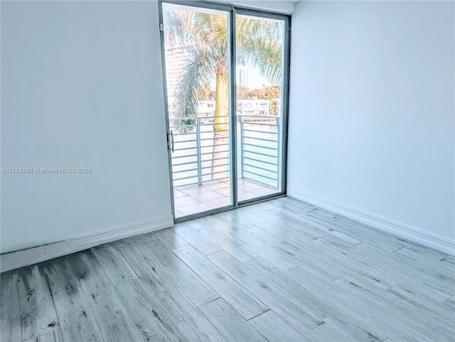 unfurnished room featuring baseboards and wood finished floors