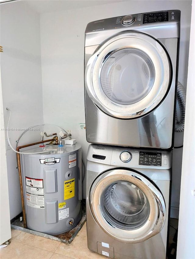 laundry room featuring stacked washer / drying machine, laundry area, electric water heater, and tile patterned flooring