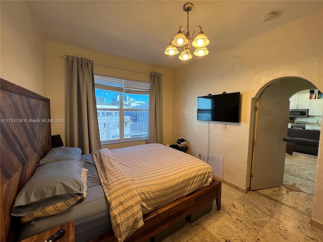 bedroom with arched walkways, visible vents, a textured wall, and baseboards