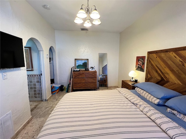 bedroom with light colored carpet, visible vents, arched walkways, and a textured wall