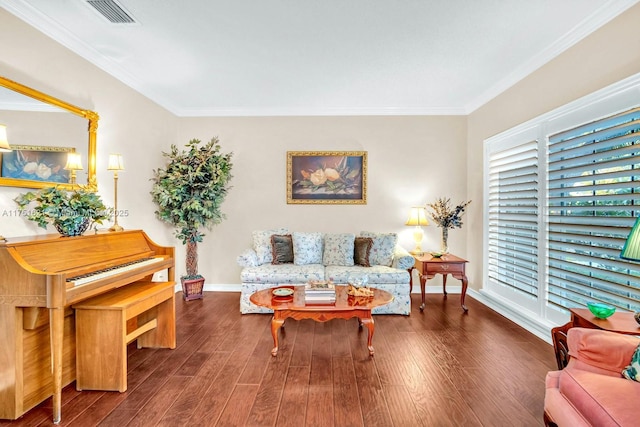 living area featuring baseboards, visible vents, wood finished floors, and ornamental molding