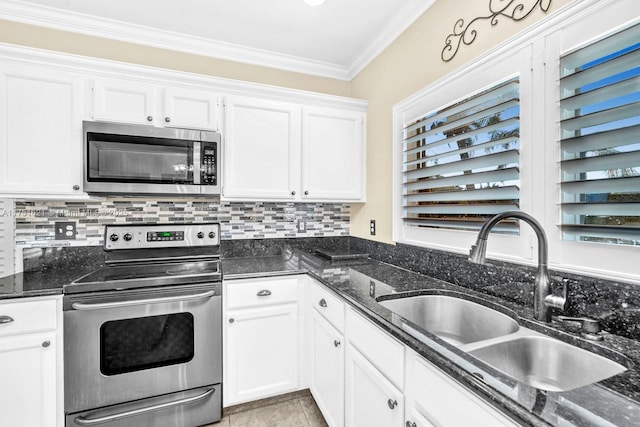 kitchen with white cabinets, decorative backsplash, appliances with stainless steel finishes, crown molding, and a sink