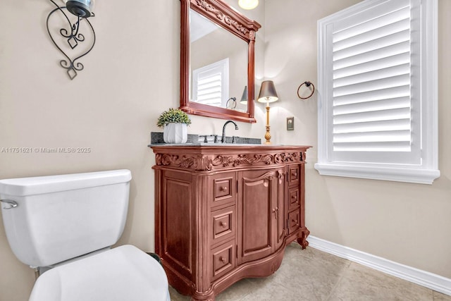 bathroom featuring baseboards, vanity, and toilet