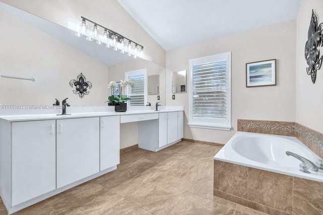 bathroom featuring lofted ceiling, double vanity, a bath, and a healthy amount of sunlight