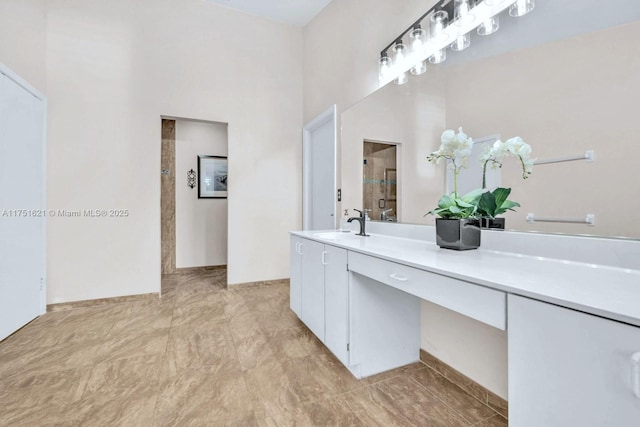 bathroom with a tile shower and vanity