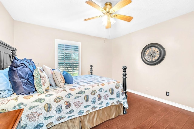 bedroom featuring ceiling fan, baseboards, and wood finished floors