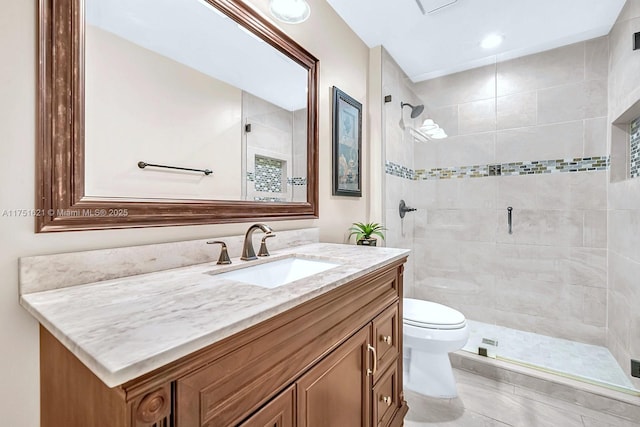 bathroom featuring toilet, a stall shower, and vanity