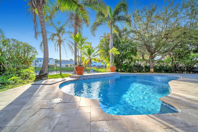 outdoor pool featuring a patio and fence