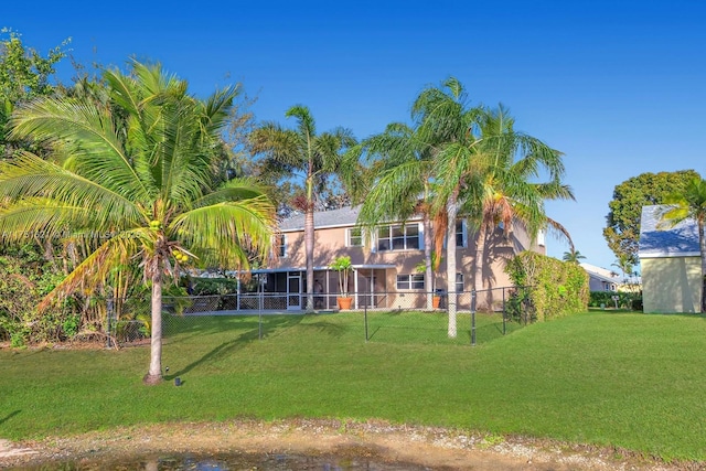 rear view of house with fence and a yard