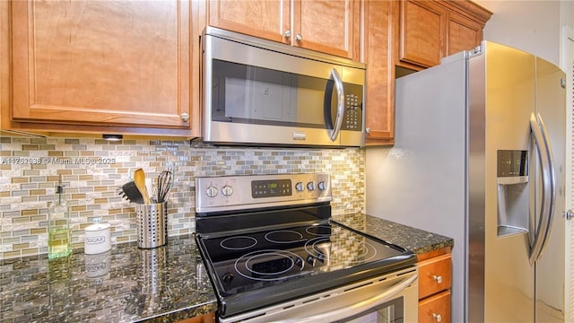 kitchen with appliances with stainless steel finishes, dark stone countertops, brown cabinets, and decorative backsplash