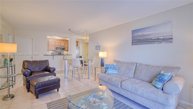 living area with baseboards and light tile patterned floors