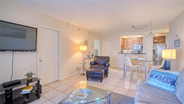 living room with light tile patterned floors, baseboards, and visible vents