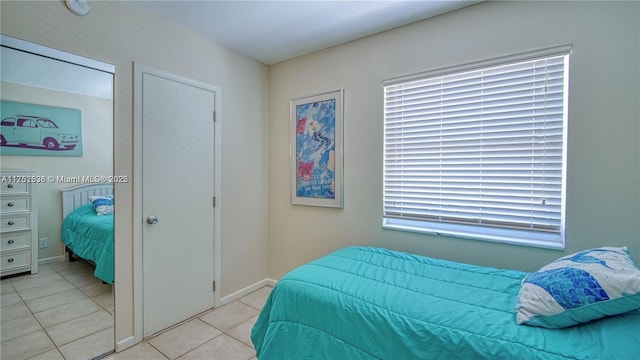 bedroom with light tile patterned floors and baseboards