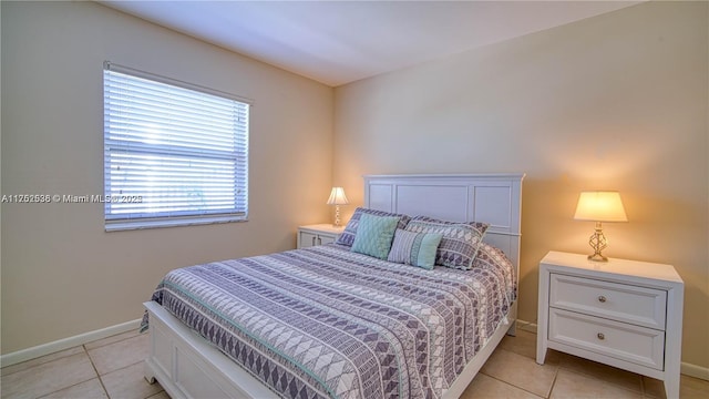 bedroom with light tile patterned flooring and baseboards