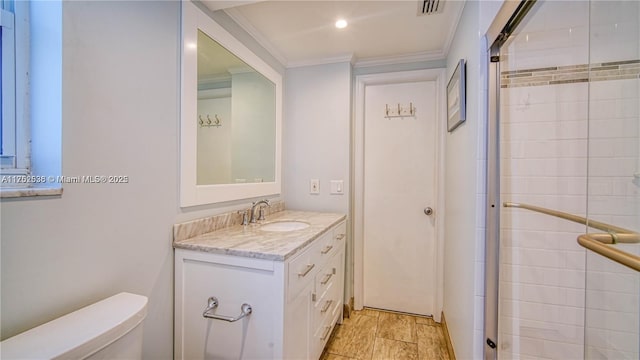 full bathroom with visible vents, toilet, a tile shower, crown molding, and vanity