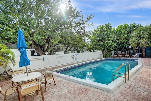 pool featuring a fenced backyard and a patio