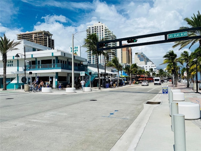 view of road with street lights, curbs, and sidewalks