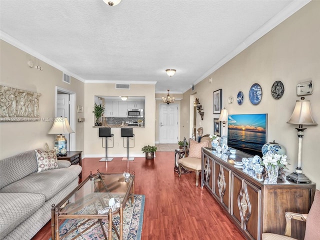 living room with visible vents, wood finished floors, and ornamental molding