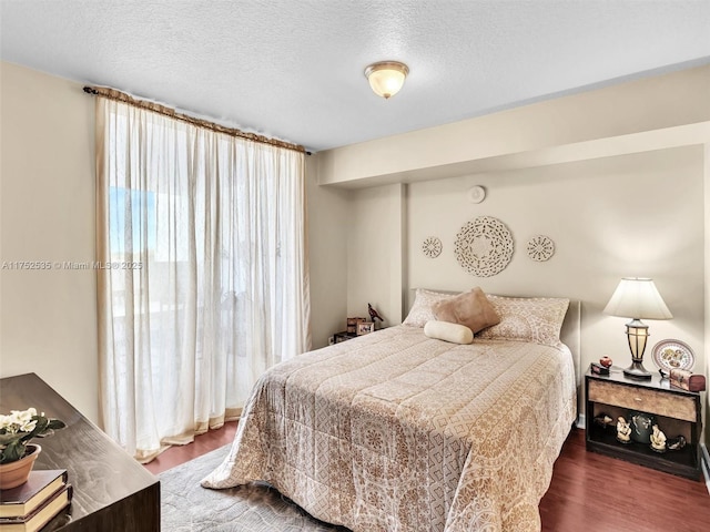 bedroom featuring a textured ceiling and wood finished floors