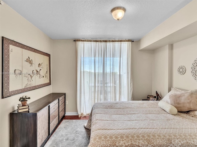 bedroom featuring a textured ceiling and wood finished floors